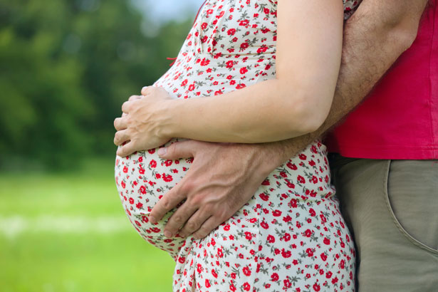 couple holding pregnant woman's belly